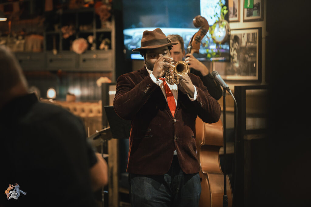 Man playing trumpet in live band.