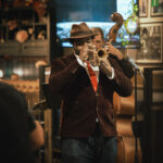 Man playing trumpet in live band.